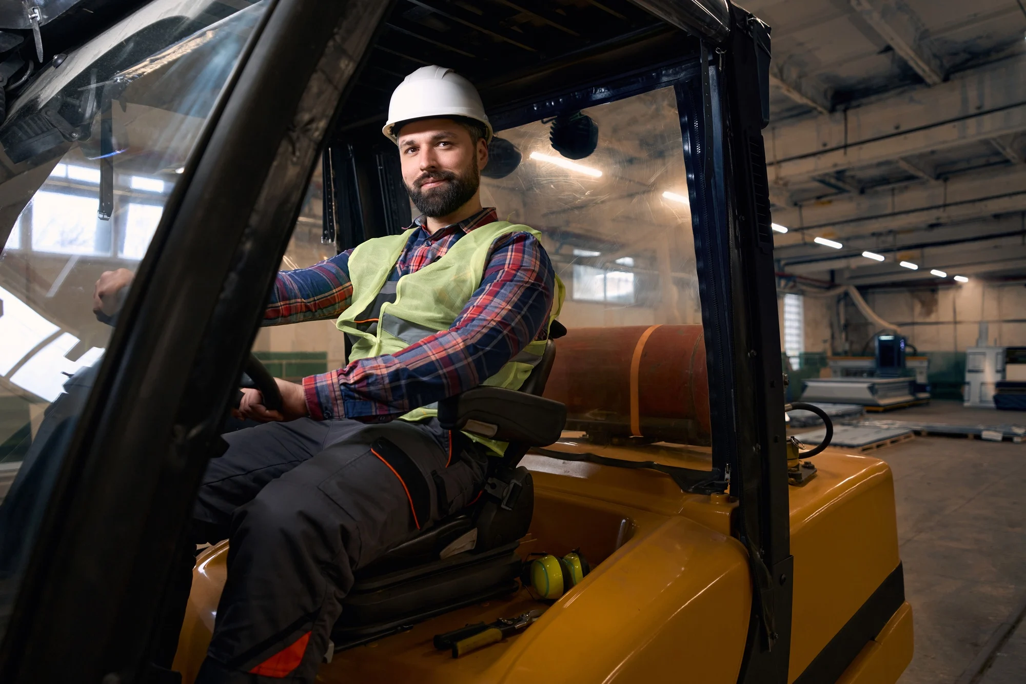 Worker transporting goods by car in the workshop